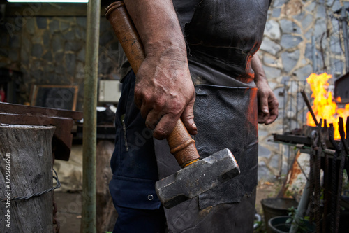 Close up of blacksmith's hand holding a hammer.