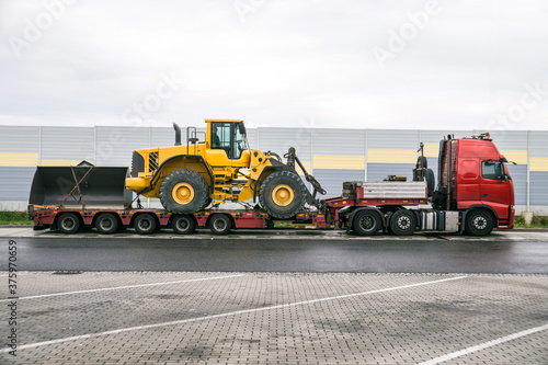 Oversize Load or exceptional convoy (convoi exceptionnel). A truck with a special semi-trailer for transporting oversized loads. Transport of a huge bulldozer.