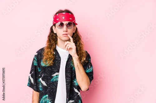 Young hippie caucasian man isolated looking sideways with doubtful and skeptical expression.