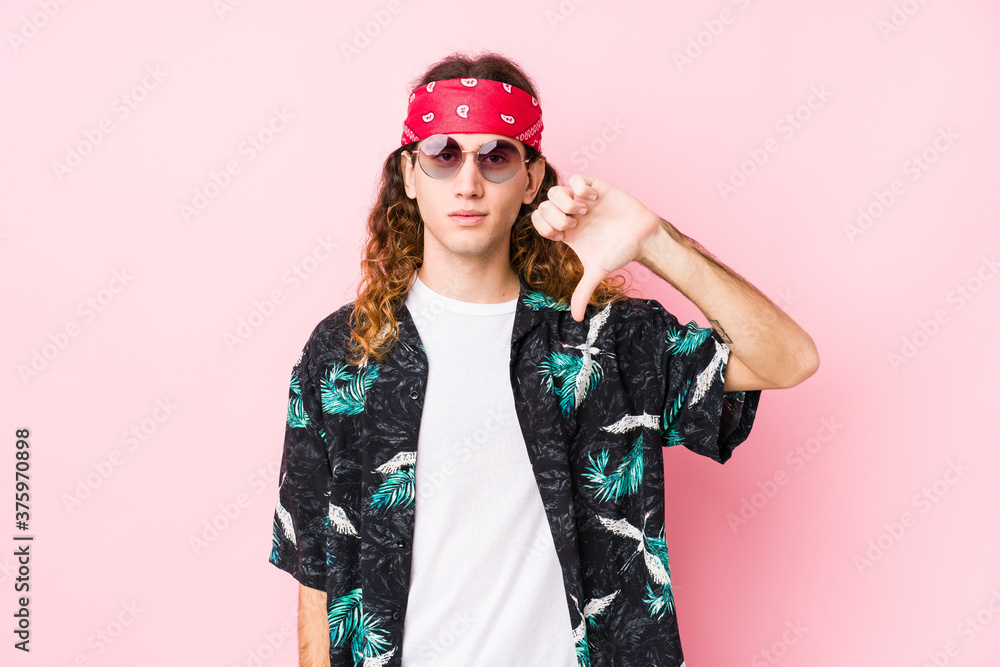 Young hippie caucasian man isolated showing a dislike gesture, thumbs down. Disagreement concept.