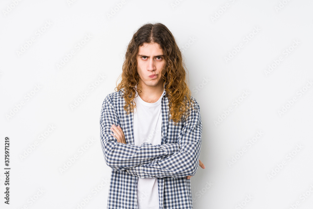 Young long hair man posing isolated frowning face in displeasure, keeps arms folded. Young long hair man posing isolated frowning face in displeasure, keeps arms folded.