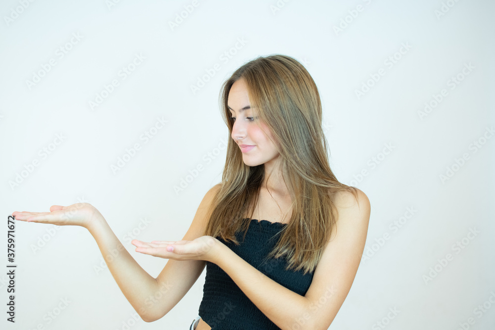 Smiling beautiful girl in black top pointing down something Smiling beautiful girl in black top pointing down something