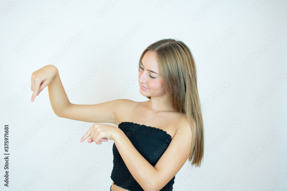 Smiling beautiful girl in black top pointing down something Smiling beautiful girl in black top pointing down something