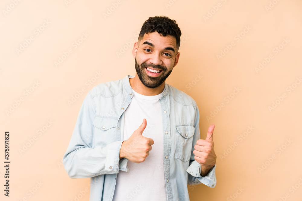 Young mixed race arabic man isolated raising both thumbs up, smiling and confident. Young mixed race arabic man isolated raising both thumbs up, smiling and confident.