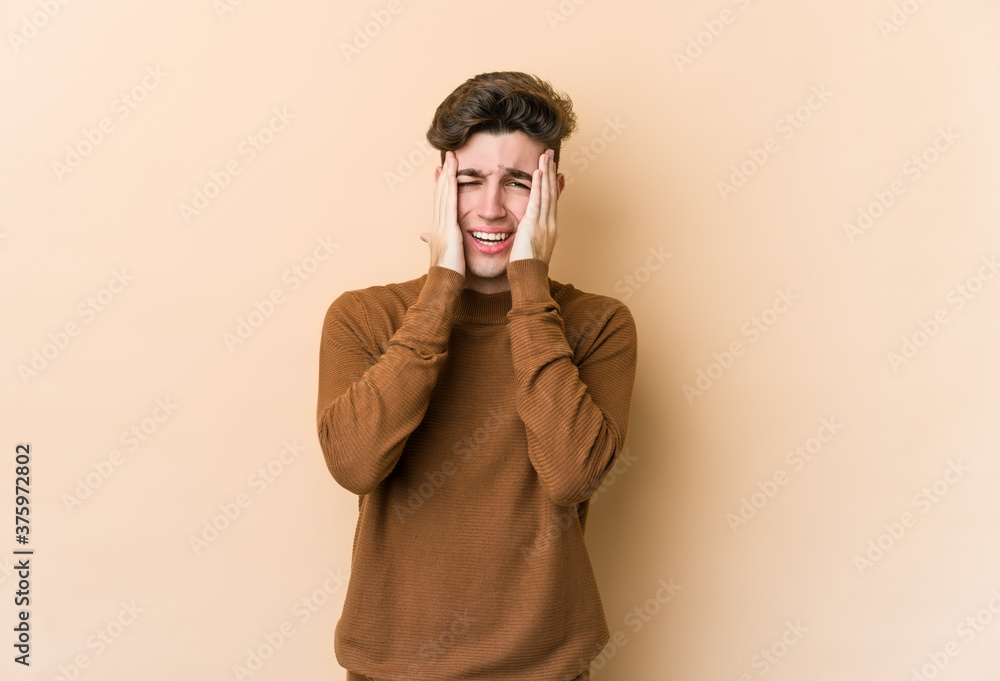 Young caucasian man isolated on beige background whining and crying disconsolately. Young caucasian man isolated on beige background whining and crying disconsolately.