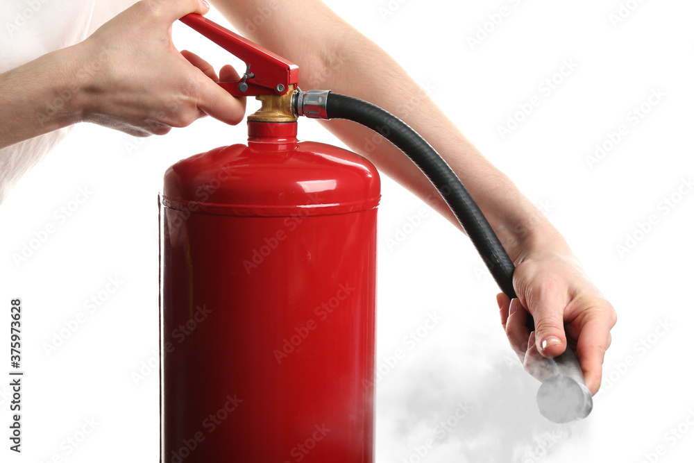 Woman using fire extinguisher on white background, closeup Woman using fire extinguisher on white background, closeup