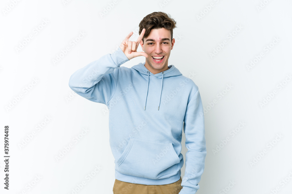 Young caucasian man isolated on white background showing a horns gesture as a revolution concept. Young caucasian man isolated on white background showing a horns gesture as a revolution concept.