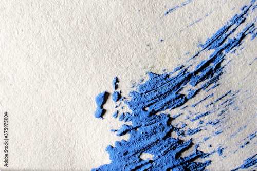 Abstract watercolor paint splash on paper background. Macro, close-up.