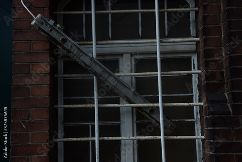 Vergitterte Fenster eines verfallenen Backsteingebäudes