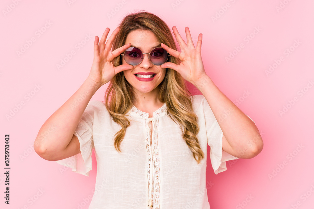 Young caucian woman with glasses isolated on pink background keeping eyes opened to find a success opportunity. Young caucian woman with glasses isolated on pink background keeping eyes opened to find a success opportunity.