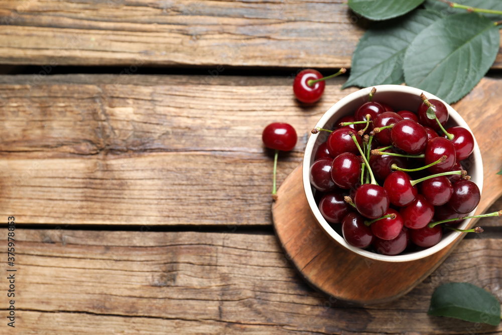 Sweet juicy cherries on wooden table, flat lay. Space for text Sweet juicy cherries on wooden table, flat lay. Space for text