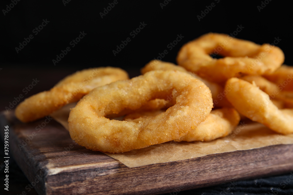 Fried onion rings served on wooden table, closeup Fried onion rings served on wooden table, closeup