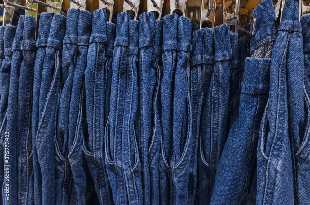 Row of hanged blue jeans. Jeans store in a shopping center. concept of buy, sell, shopping and jeans fashion.