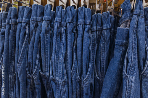 Row of hanged blue jeans. Jeans store in a shopping center. concept of buy, sell, shopping and jeans fashion.