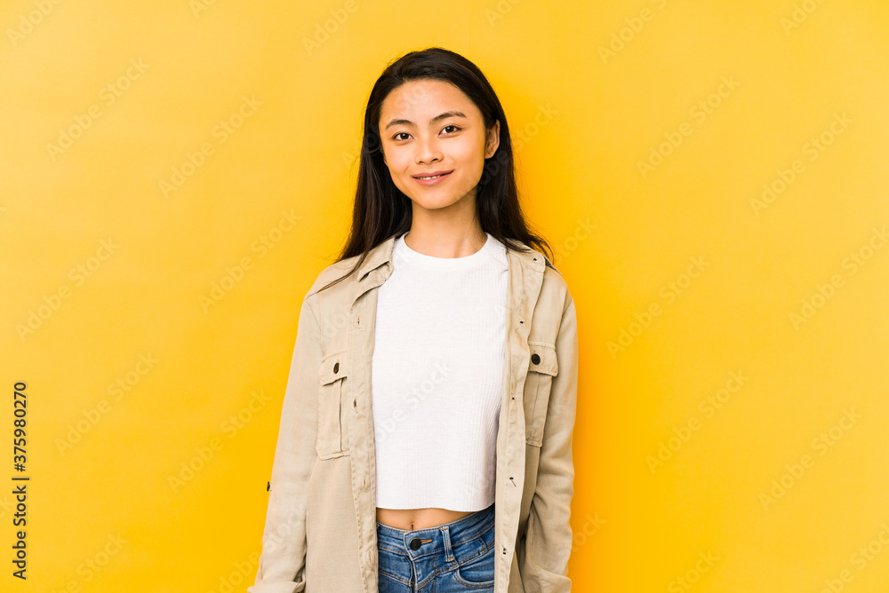 Young chinese woman isolated on a yellow background happy, smiling and cheerful. Young chinese woman isolated on a yellow background happy, smiling and cheerful.