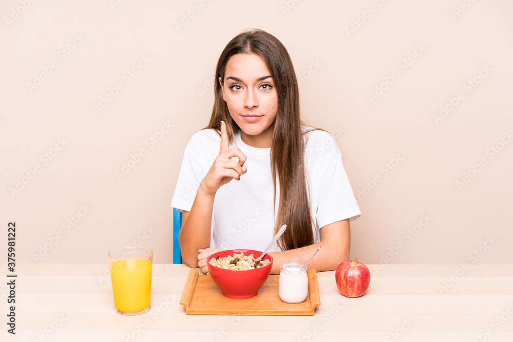 Young caucasian woman having a breakfast isolated showing number one with finger. Young caucasian woman having a breakfast isolated showing number one with finger.