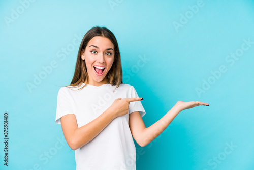 Young caucasian woman  isolated excited holding a copy space on palm.