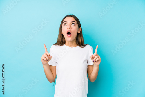 Young caucasian woman  isolated pointing upside with opened mouth.
