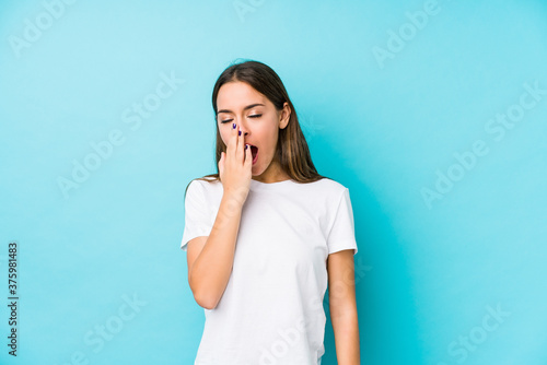 Young caucasian woman isolated yawning showing a tired gesture covering mouth with hand.