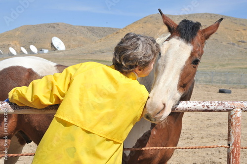 Female rancher bonding with horse.