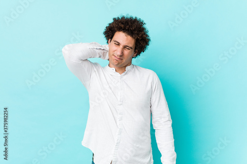 Young curly mature man wearing an elegant shirt suffering neck pain due to sedentary lifestyle.