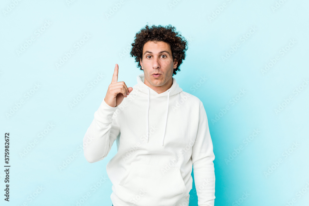 Young sporty man against a blue background having some great idea, concept of creativity. Young sporty man against a blue background having some great idea, concept of creativity.