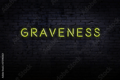 Fototapet Night view of neon sign on brick wall with inscription graveness