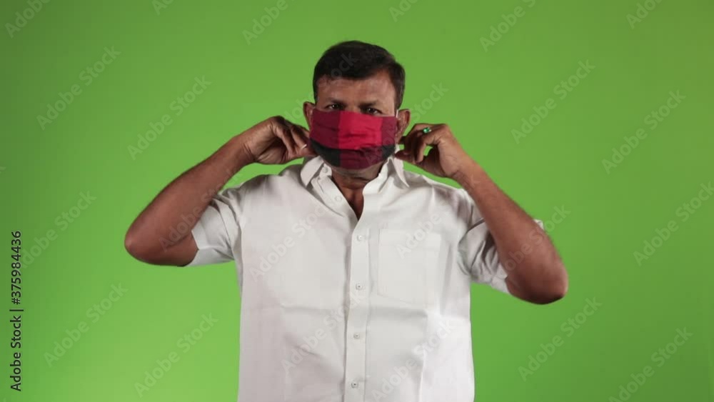 Corona virus concept. Close up portrait of an asian men wearing black face mask to prevent COVID 19 corona virus over green screen. Self isolation from virus. Corona virus concept. Close up portrait of an asian men wearing black face mask to prevent COVID 19 corona virus over green screen. Self isolation from virus.