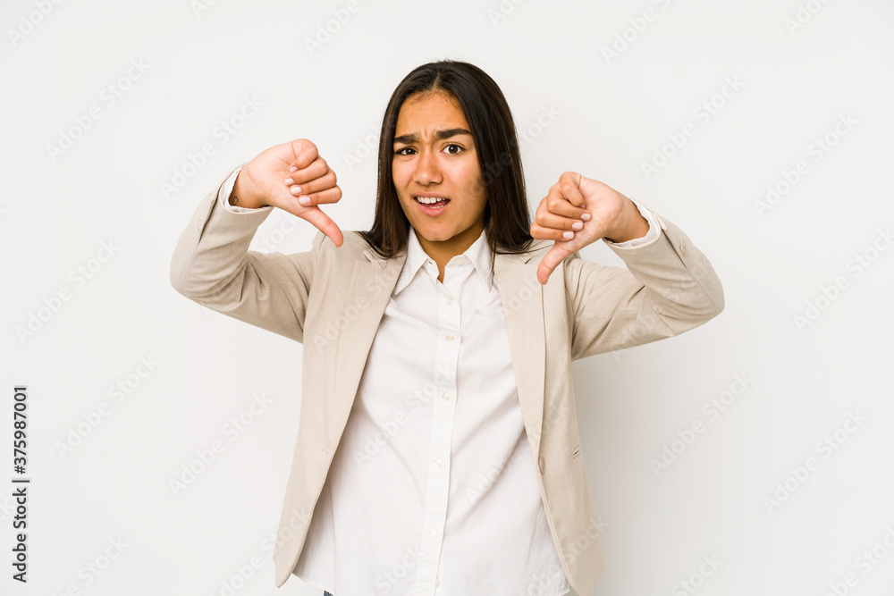 Young woman isolated on a white background showing thumb down and expressing dislike. Young woman isolated on a white background showing thumb down and expressing dislike.