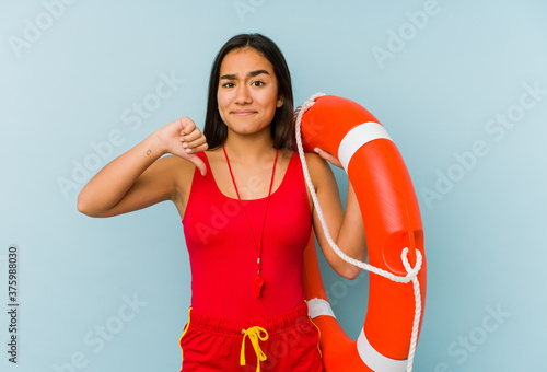 Young asian lifeguard woman isolated showing a dislike gesture, thumbs down. Disagreement concept.