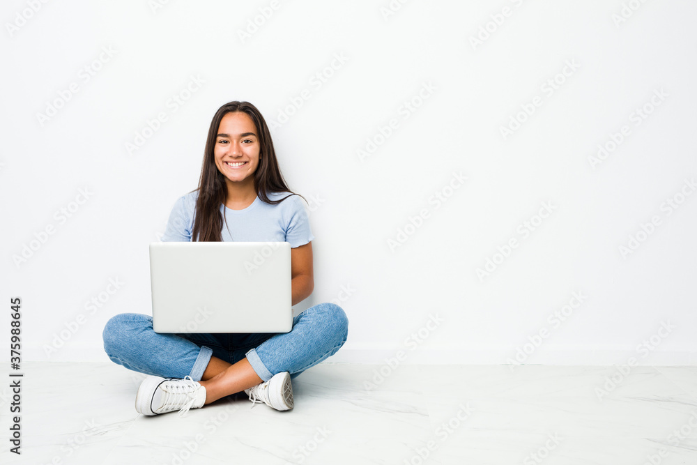 Young mixed race indian woman sitting working on laptop happy, smiling and cheerful. Young mixed race indian woman sitting working on laptop happy, smiling and cheerful.