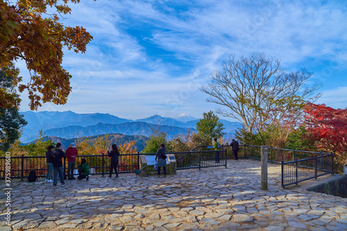 東京八王子市の秋の高尾山頂のハイカーと大見晴園地から南西側方面(富士山など)