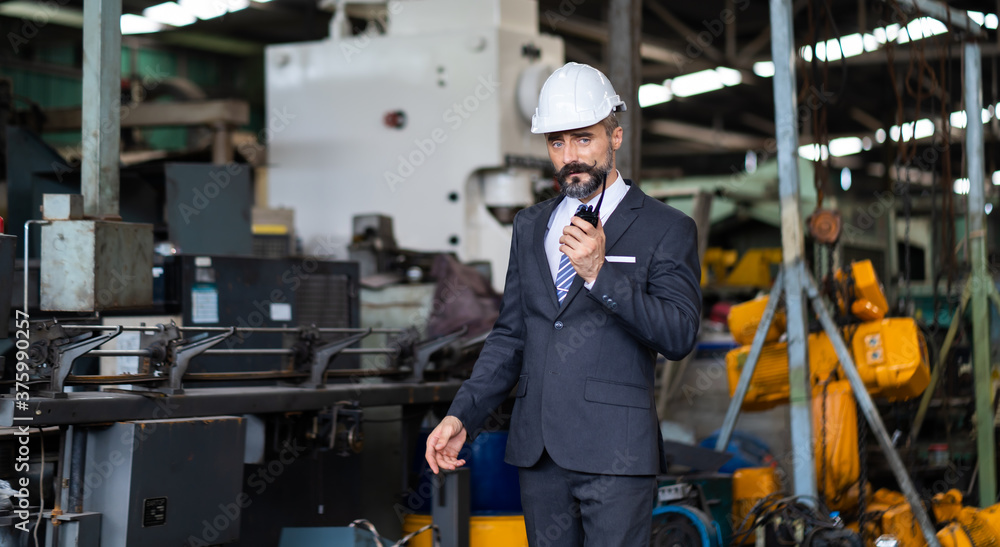 Man at work. Mechanical Engineer Bearded man in Hard Hat in Heavy Industry Manufacturing Facility. Professional Engineer Operating lathe Machinery Man at work. Mechanical Engineer Bearded man in Hard Hat in Heavy Industry Manufacturing Facility. Professional Engineer Operating lathe Machinery