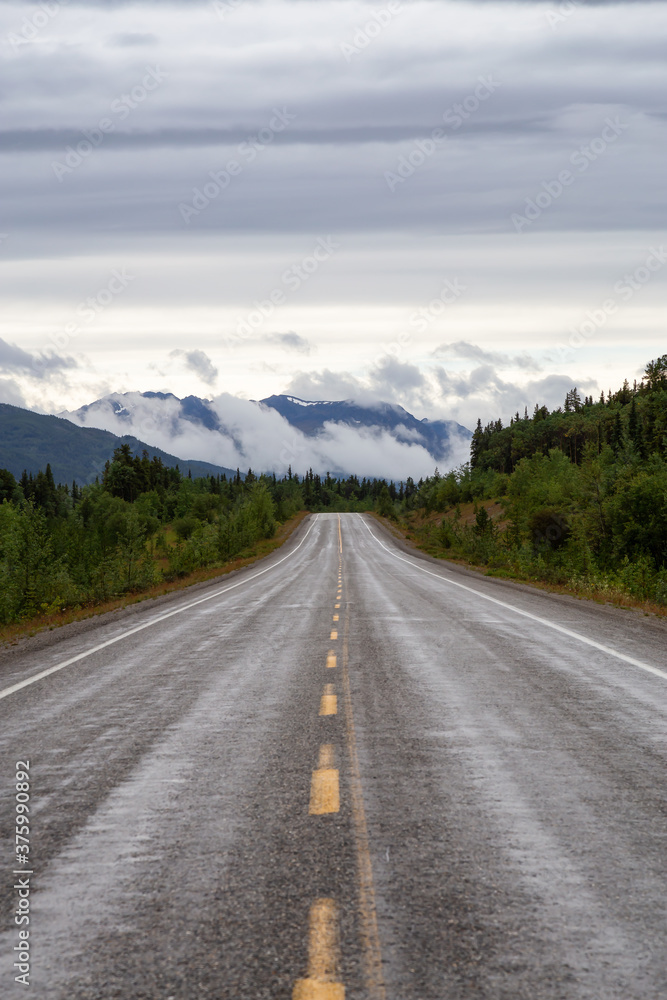 Beautiful View of a scenic road in the Northern Rockies during a sunny and cloudy morning. Taken in British Columbia, Canada. Nature Background