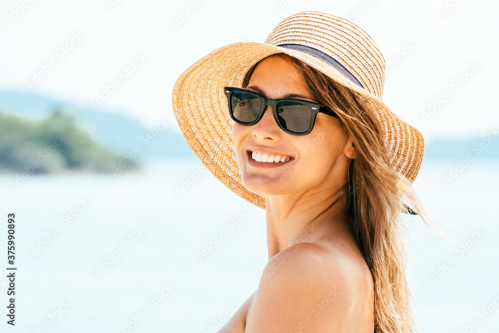 Portrait young woman wearing a straw hat on beach Portrait young woman wearing a straw hat on beach