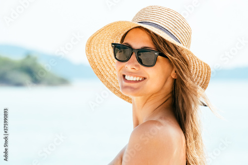 Portrait young woman wearing a straw hat on beach