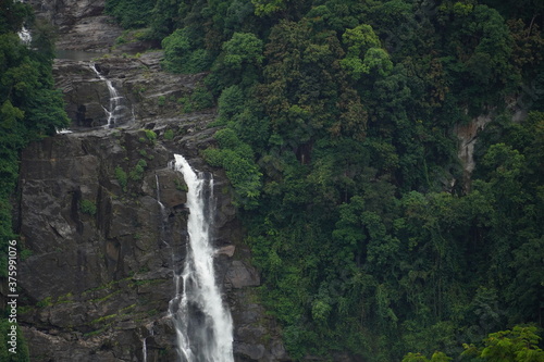 Arial view of a High waterfall in the green forest. stream of water falling down in the middle. Rain forest in Sri Lanka, as a natural concept of travel photography.