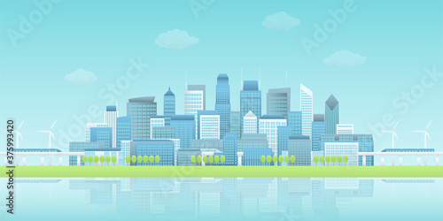 Panoramic view of buildings group in waterfront smart city with sky trains, wind turbines, trees in clear blue sky