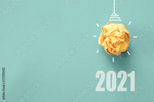2021 Yellow paper light bulb on blue background, innovative business vision and resolution concept