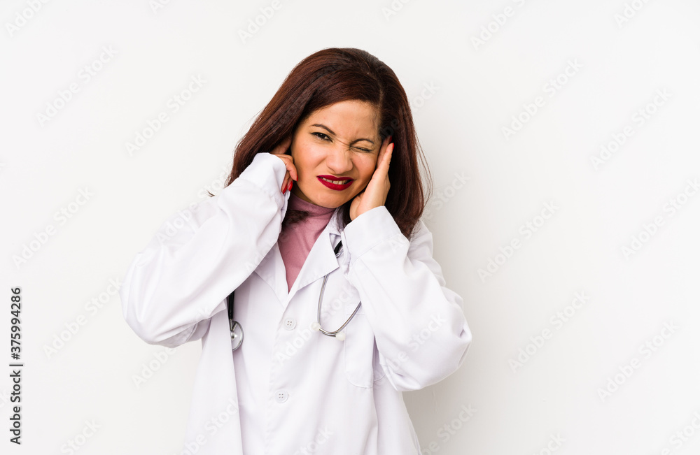 Middle age latin doctor woman isolated covering ears with hands. Middle age latin doctor woman isolated covering ears with hands.