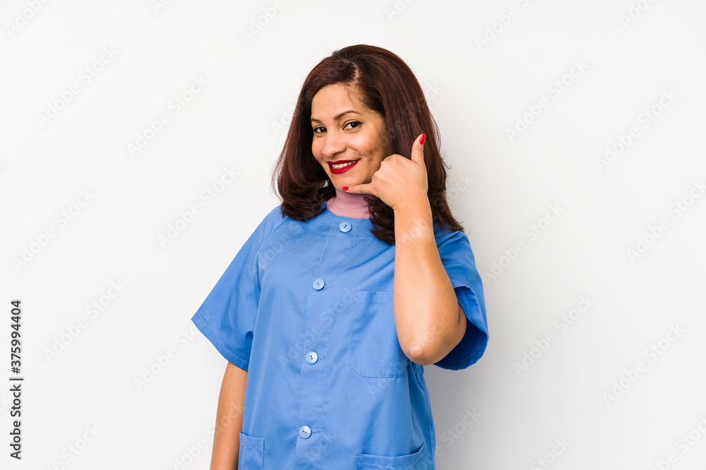 Middle age latin nurse woman isolated çshowing a mobile phone call gesture with fingers. Middle age latin nurse woman isolated çshowing a mobile phone call gesture with fingers.