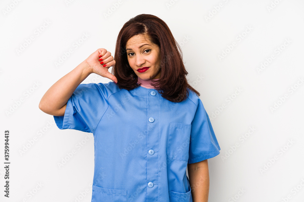 Middle age latin nurse woman isolated çshowing a dislike gesture, thumbs down. Disagreement concept. Middle age latin nurse woman isolated çshowing a dislike gesture, thumbs down. Disagreement concept.