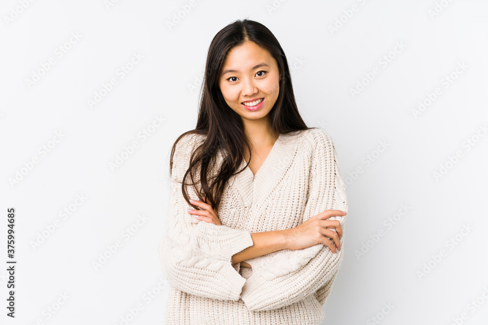 Young chinese woman isolated who feels confident, crossing arms with determination. Young chinese woman isolated who feels confident, crossing arms with determination.