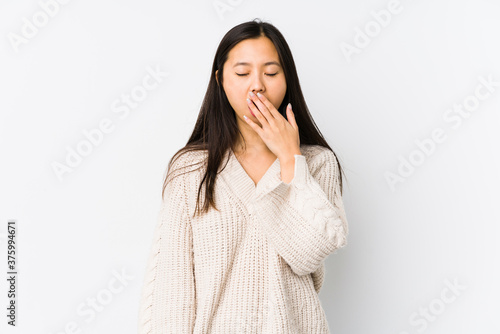 Young chinese woman isolated yawning showing a tired gesture covering mouth with hand.