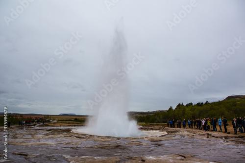 The Strokkur Geyser in Iceland  on a cloudy day.