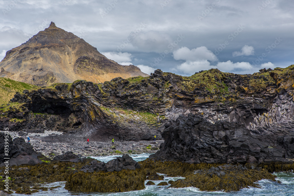 Obraz premium The volcanic black basalt landscape at the coast of Hellnar, a small town in Snaefellsnes, Iceland.