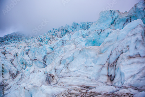 Close view of the blue glaciers in Vatnajokull National Park, in Iceland, on a cloudy day.