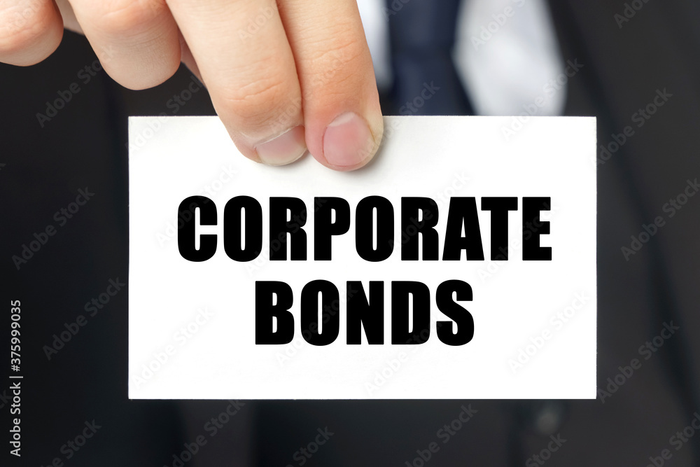 Businessman shows a card with the text - CORPORATE BONDS Businessman shows a card with the text - CORPORATE BONDS