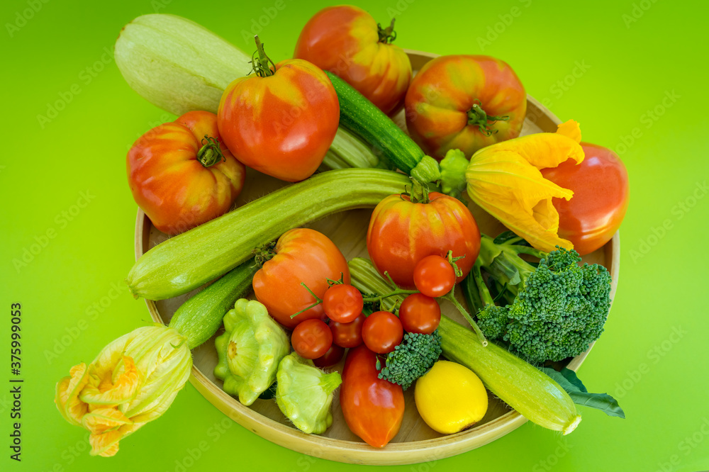 Plate with fresh vegetables on green background Plate with fresh vegetables on green background