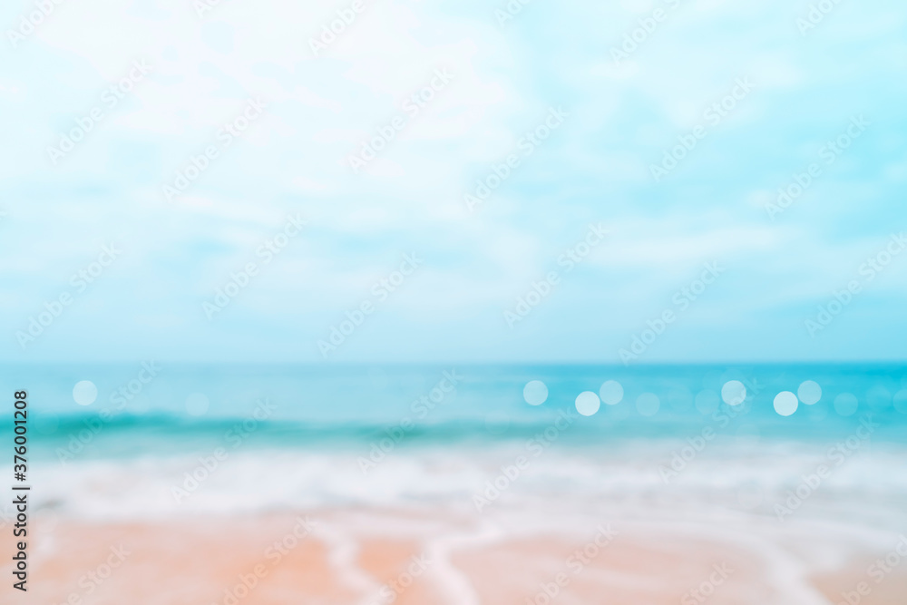 Fototapeta premium Blur tropical nature clean beach and white sand in summer with sun light blue sky and bokeh